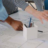 close-up-architects-doing-teamwork-design-blueprints-plans-building-model-table-team-women-working-with-industrial-sketch-layout-print-plan-architectural-project close-up-architects-doing-teamwork-design-blueprints-plans-building-model-table-team-women-working-with-industrial-sketch-layout-print-plan-architectural-project
