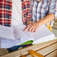 handsome-young-carpenter-working-with-experienced-man handsome-young-carpenter-working-with-experienced-man